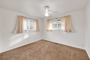 Empty room featuring carpet flooring and ceiling fan