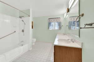 Full bathroom with double vanity, shower / washtub combination, and light tile patterned floors