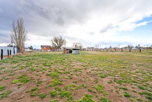 View of yard featuring a view of rural / pastoral area, an outdoor structure, and an outbuilding