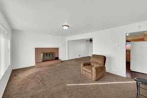 Sitting room with carpet, a fireplace, and a ceiling fan