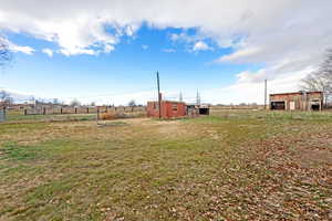 View of yard featuring an outdoor structure, a view of rural / pastoral area, and an outbuilding