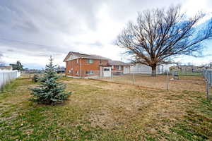 Rear view of house featuring a fenced backyard and roof mounted solar panels