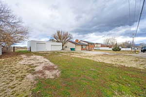 Rear view of house featuring a garage and an outbuilding