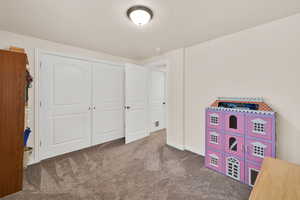 Rec room featuring a textured ceiling and carpet flooring