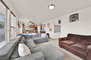 Living room with light colored carpet and a ceiling fan