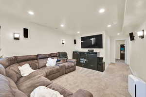Carpeted living area featuring recessed lighting and baseboards