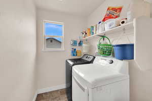 Laundry area featuring washer and dryer and baseboards