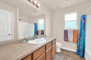 Bathroom featuring vanity and shower / bath combo with shower curtain