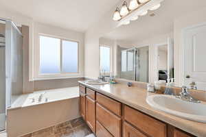 Ensuite bathroom with double vanity, a bath, and a stall shower