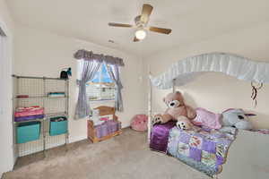 Carpeted bedroom with a ceiling fan and baseboards