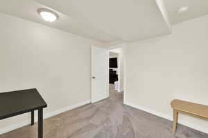 Carpeted spare room with baseboards and a smoke detector