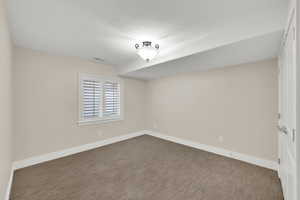 Carpeted empty room with baseboards and a textured ceiling