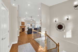 Hall with an upstairs landing, a chandelier, wood finished floors, and recessed lighting