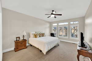 Carpeted bedroom with baseboards and ceiling fan