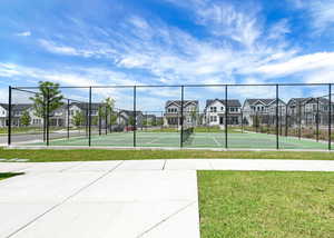 View of tennis court with a residential view