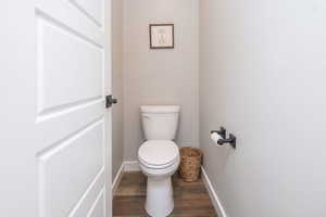 Bathroom featuring baseboards and dark wood finished floors