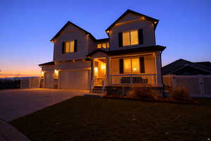 View of front of home with covered porch, an attached garage, and concrete driveway