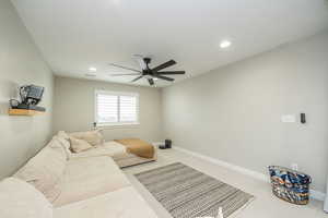 Carpeted living room with recessed lighting and ceiling fan