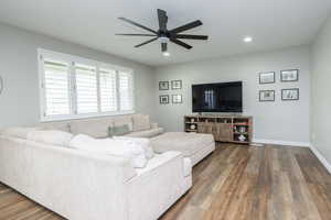 Living area with wood finished floors, ceiling fan, and recessed lighting