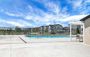 Community pool featuring a patio and a residential view