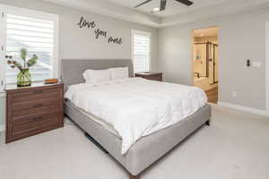 Bedroom featuring recessed lighting, light colored carpet, a ceiling fan, ensuite bathroom, and a barn door