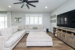Living room featuring dark wood-style floors, recessed lighting, and a ceiling fan