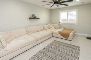 Living room featuring carpet and ceiling fan