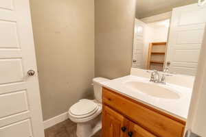 Half bathroom with vanity, light tile patterned flooring, and a textured wall