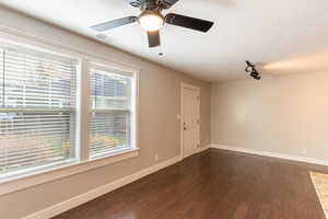 Living  room featuring dark wood finished floors, a textured ceiling, and a ceiling fan