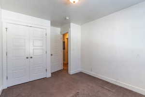 Bedroom #3  with a closet, dark carpet, and a textured ceiling