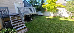 Fenced backyard featuring stairs and a deck