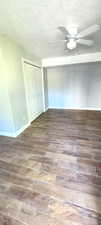 Spare room featuring wood tiled floors, a ceiling fan, and a textured ceiling