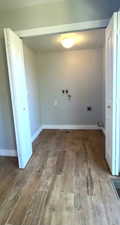 Laundry room featuring wood finished floors, washer hookup, and electric dryer hookup