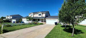 Traditional-style house with an attached garage, a porch, and concrete driveway