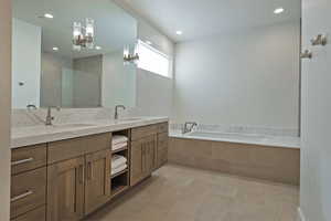 Full bathroom with double vanity, a garden tub, recessed lighting, a tile shower, and light tile patterned floors