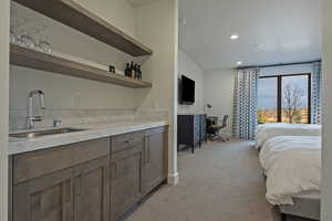 Bedroom with a desk, light colored carpet, and recessed lighting