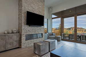 Living room featuring hardwood / wood-style flooring and a stone fireplace