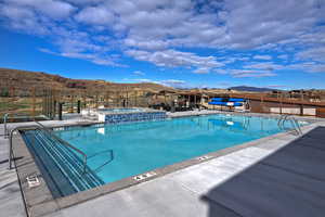 Community pool featuring a mountain view, a patio, and a community hot tub