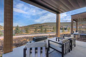 View of patio / terrace featuring a mountain view and an outdoor living space with a fire pit