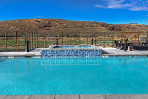 Community pool featuring an in-ground hot tub and a patio area