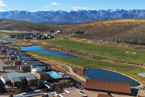Aerial view of residential area featuring a water and mountain view and a golf course