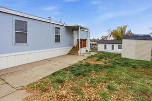 View of front of home featuring a storage unit and a front lawn