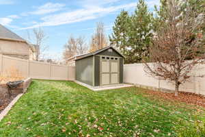 Fenced backyard featuring a storage shed