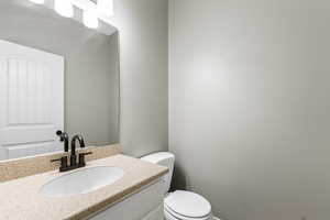 Half bathroom with vanity and toilet