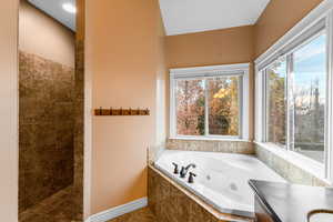 Bathroom with vanity, a tub with jets, and walk in shower