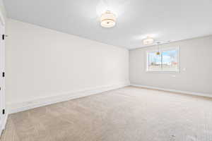 Unfurnished room featuring carpet and a textured ceiling