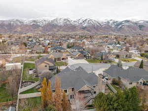 Aerial view of property and surrounding area with mountains and nearby suburban area