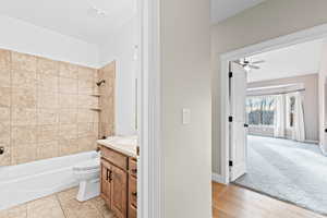 Bathroom featuring vanity, washtub / shower combination, and ceiling fan