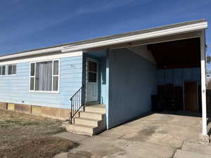 Entrance to property featuring a carport and driveway