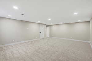 Basement with recessed lighting and light colored carpet